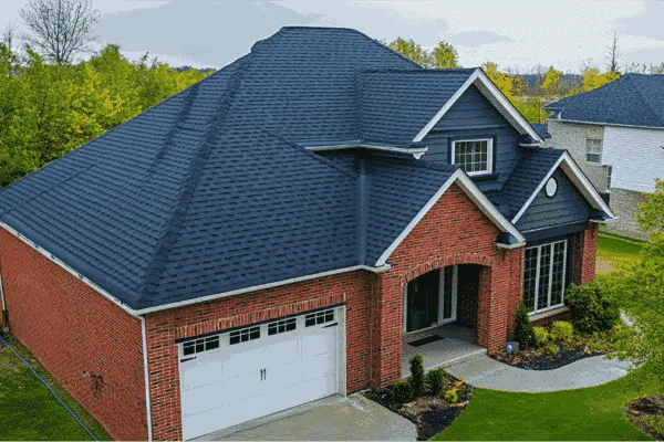 Aerial view of a brick home with a dark shingle roof.