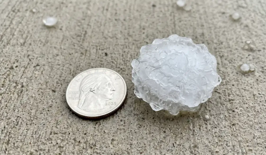 Hailstone beside a coin for size comparison