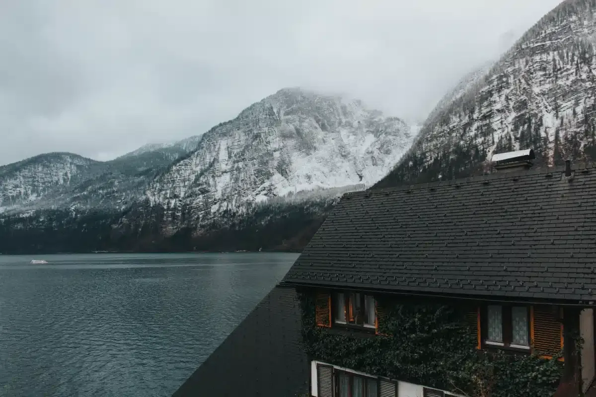 A house in snowy mountains with dark roof shingles