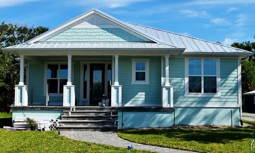 Pastel blue house with front porch.