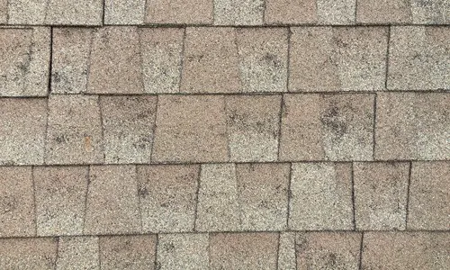Closeup of weathered asphalt roof shingles.