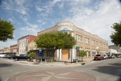 A corner building and nearby shops in downtown Yoakum.