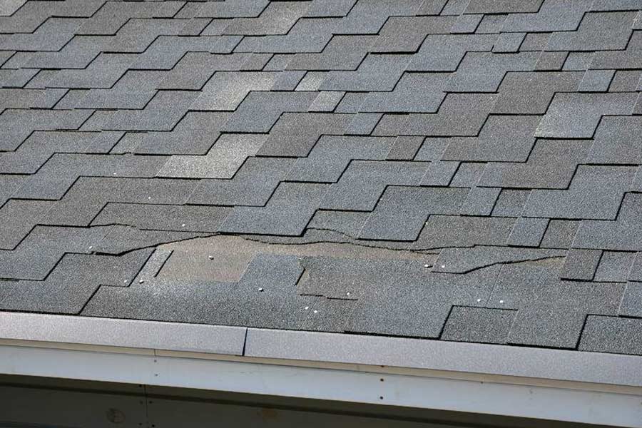 Roof with damaged shingles identified by our Cuero roofing company