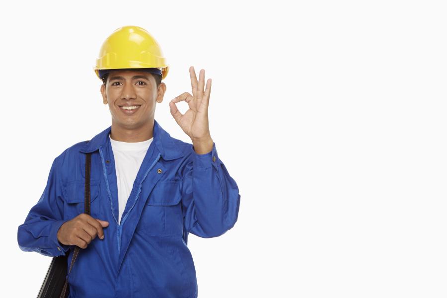 Worker wearing helmet and smiling on white background
