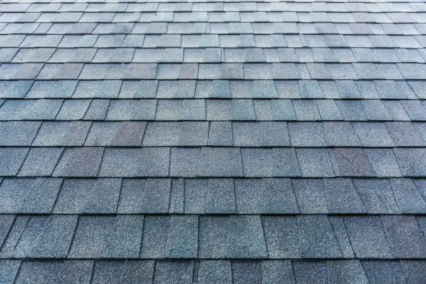 How Many Roofing Squares Does Your Roof Need? 70 Blue asphalt shingle roof surface closeup.