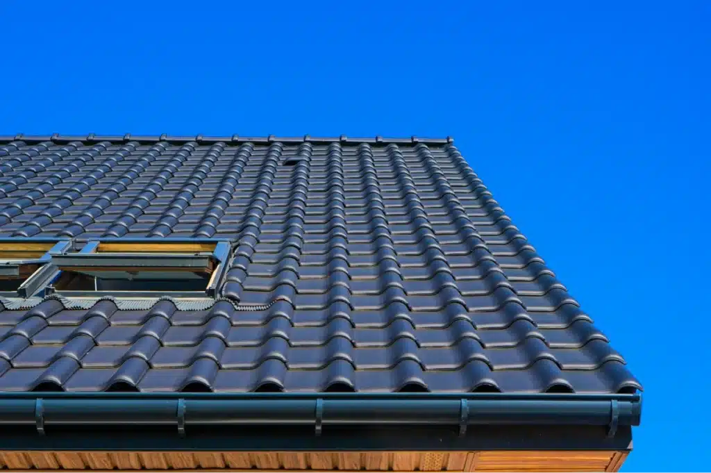 Dark roof with dark blue shingles and the sky in the background