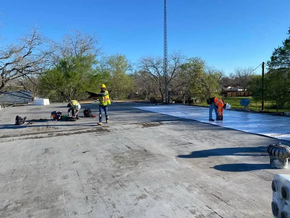 Workers roofing a flat commercial roof