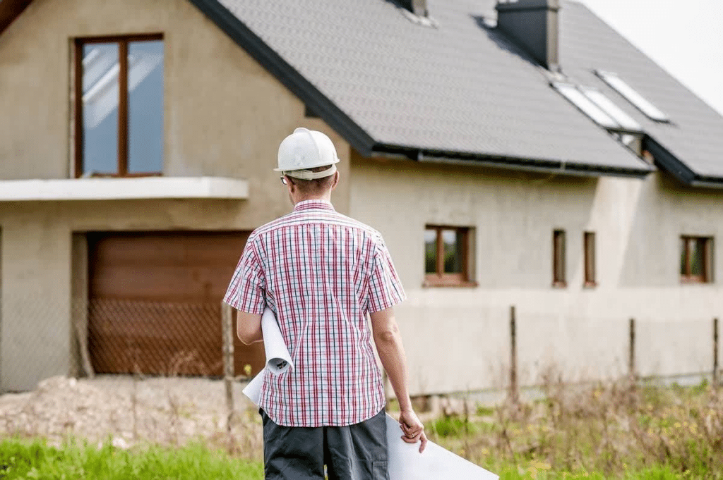 Architect in hard hat inspecting a house construction.